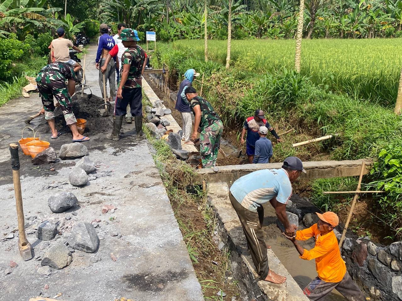 Anggota Satgas TNI Manunggal Membangun Desa (TMMD) ke-126 Kodim 0818/Malang-Batu terus menunjukkan dedikasi tinggi dalam melaksanakan pekerjaan peningkatan saluran irigasi di Desa Lebakharjo, Kecamatan Ampelgading, Kabupaten Malang.