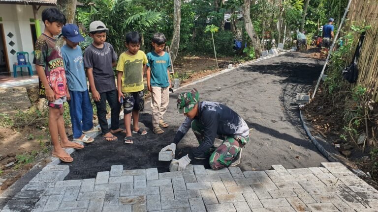 Anak-Anak Antusias Saksikan Pemasangan Paving TMMD Ke-128 di Desa Brabe. 